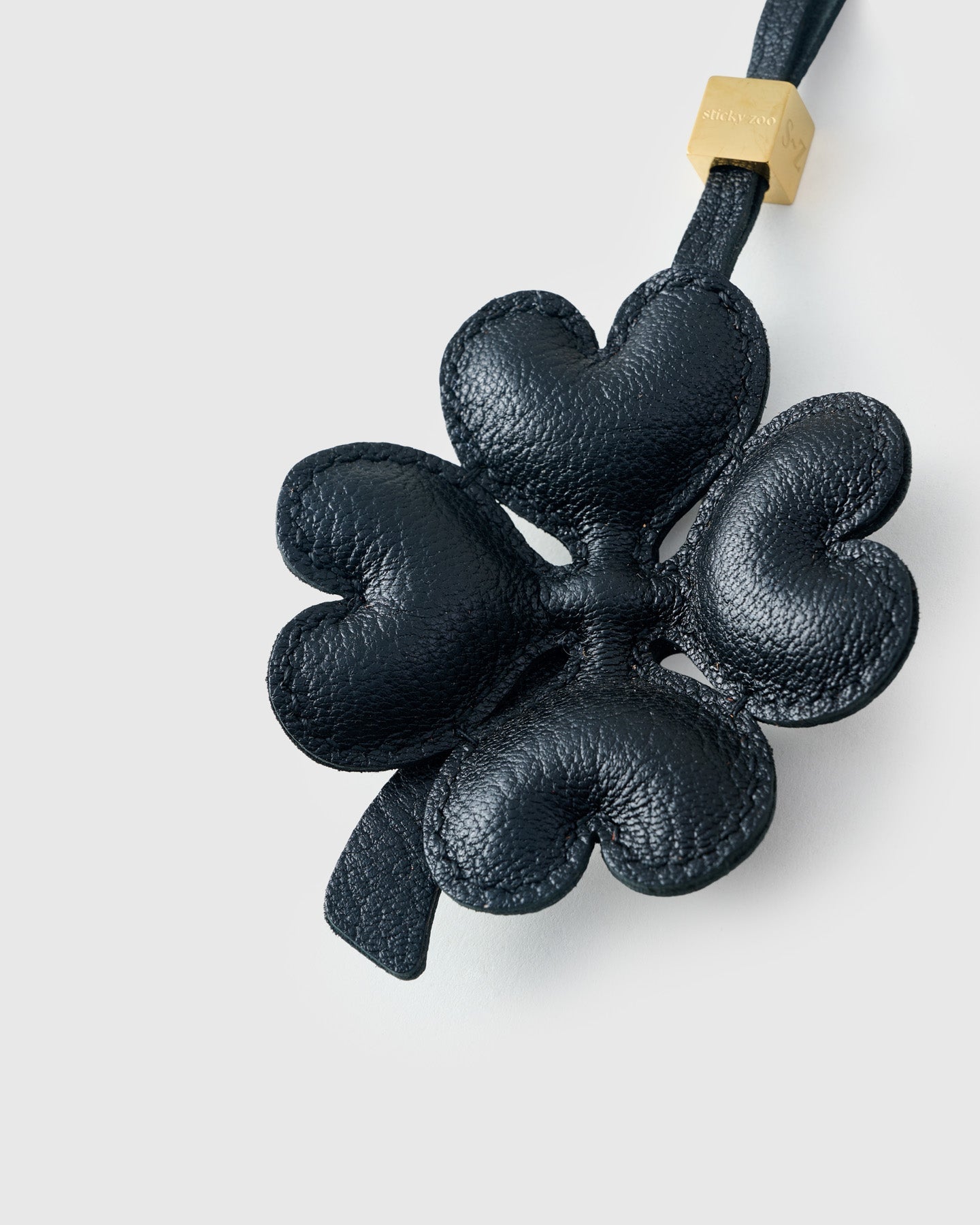 Close-up of STICKYZOO Lucky Clover Charm — full-grain French Alran goatskin from Tarn, France. Padded heart-shaped petals. 3-day handmade piece.