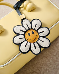 Close-up of STICKYZOO Smile Flower Charm — full-grain French Alran goatskin from Tarn, France. Daisy petals with smiley face centre. 3-day handmade piece.