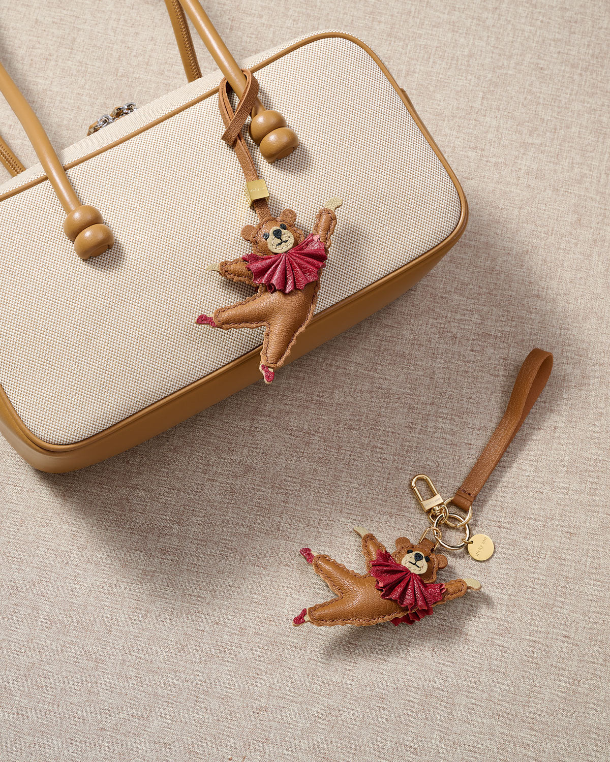Close-up of the ballet bear charm — hand-cut and hand-stitched panels of French Alran goatskin. Every layer by hand.
