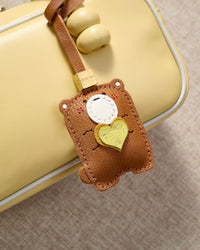 TEDDY BEAR CHARM charm styled on a bag — a small, specific piece that turns a simple bag into a personal one.