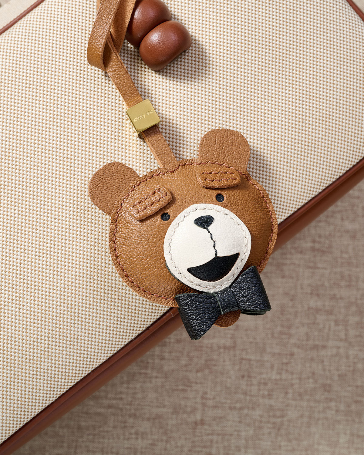 TEDDY BEAR CHARM charm styled on a bag — a small, specific piece that turns a simple bag into a personal one.