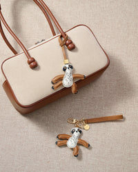 Close-up of the sloth charm — hand-cut and hand-stitched panels of French Alran goatskin. Every layer by hand.