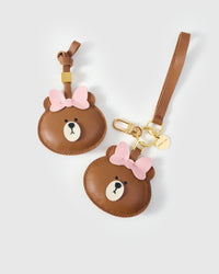 Both editions of the cuddly bear charm — leather strap loop for bags, or 18K gold-plated keychain clip.