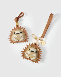 Both editions of the hedgehog charm — leather strap loop for bags, or 18K gold-plated keychain clip.