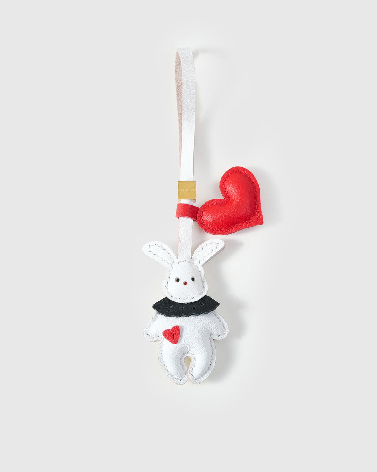 RABBIT CHARM charm handmade from French Alran genuine goatskin — A white rabbit holding a red heart, with a black collar and. Three days by hand. Arrives in luxury gift packaging. Designed in Amsterdam.