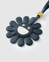 STICKYZOO Night Flower Charm — hand-layered French Alran goatskin, black petals with smiley face centre. Designed in Amsterdam.