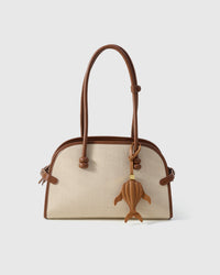 Caramel whale charm on a bag, side angle — loved by thousands of ocean lovers. Real French leather, 3 days by hand.