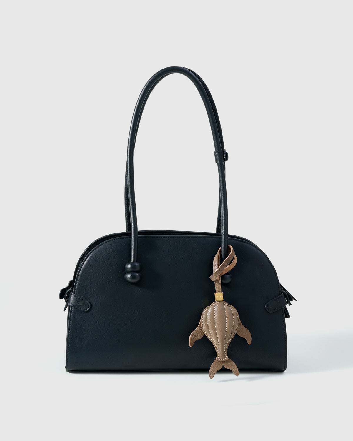Taupe whale charm on a bag, side angle — 5,000+ reviews across STICKYZOO. Real French leather, 3 days by hand.