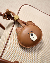 Close-up of the cuddly bear charm — hand-cut and hand-stitched panels of French Alran goatskin. Every layer by hand.