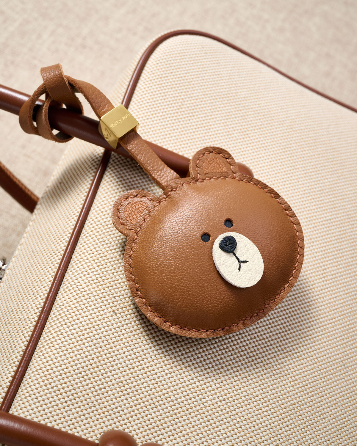 Close-up of the cuddly bear charm — hand-cut and hand-stitched panels of French Alran goatskin. Every layer by hand.