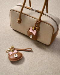 Close-up of the cuddly bear charm — hand-cut and hand-stitched panels of French Alran goatskin. Every layer by hand.