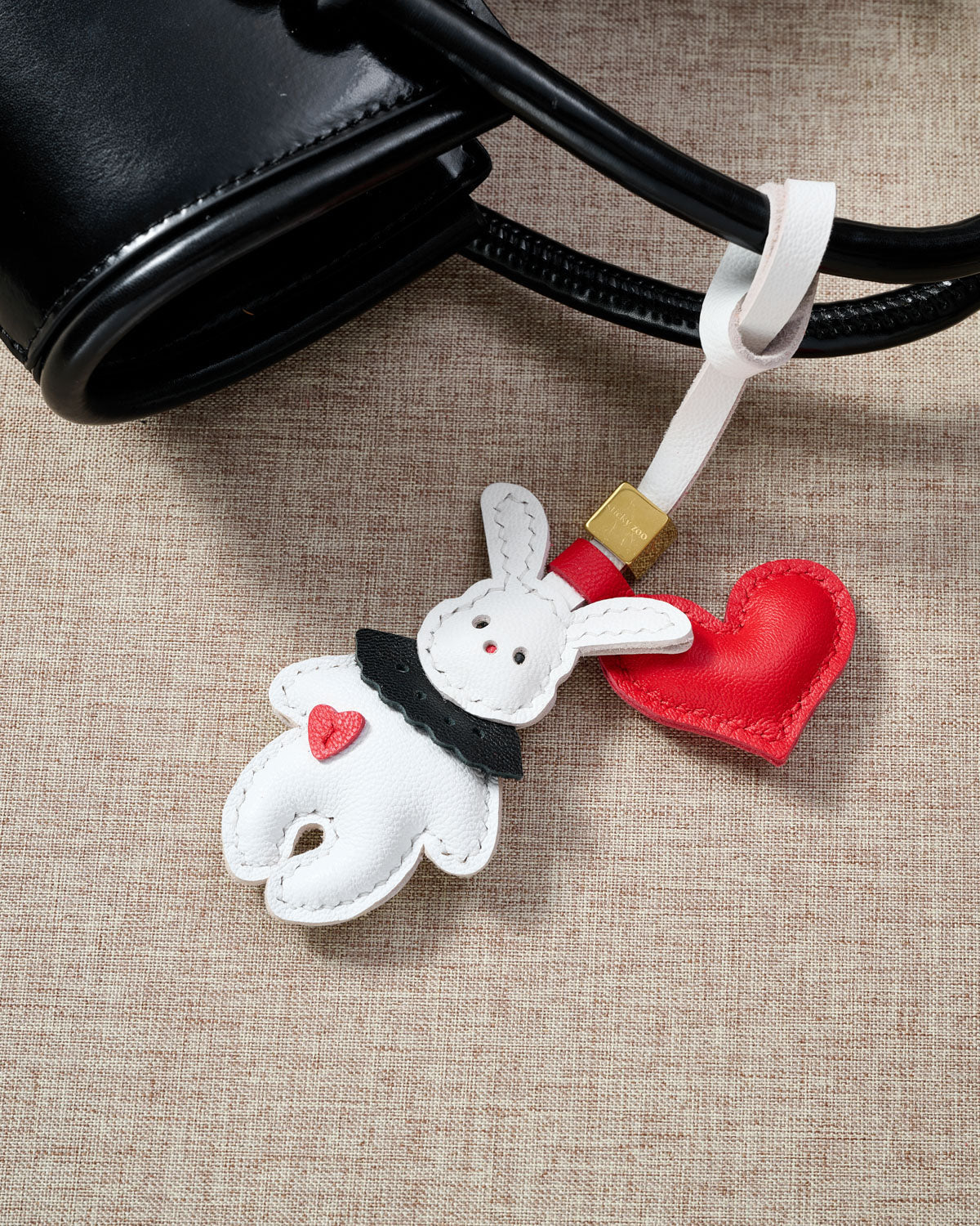RABBIT CHARM charm styled on a bag — a small, specific piece that turns a simple bag into a personal one.