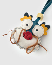 Colorful dragon charm on a bag, side angle — 5,000+ reviews across STICKYZOO. Real French leather, 3 days by hand.