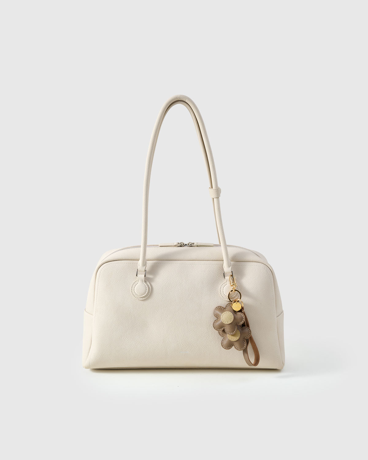 Close-up of STICKYZOO Twin Flowers Charm — full-grain French Alran goatskin from Tarn, France. Twin five-petal blooms on gold keychain. 3-day handmade piece.