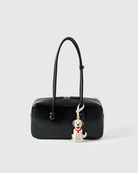 Handmade Golden Retriever leather bag charm clipped to a handbag — French Alran goatskin, 5-day artisan build. STICKYZOO.
