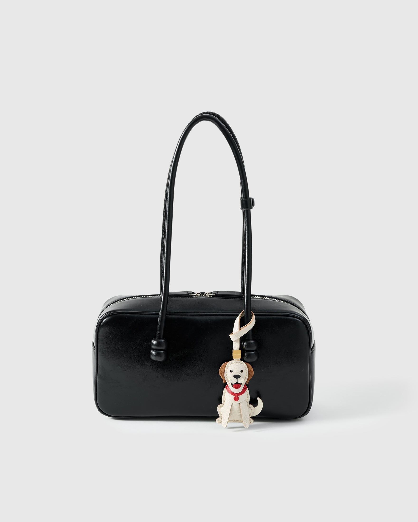 Handmade Golden Retriever leather bag charm clipped to a handbag — French Alran goatskin, 5-day artisan build. STICKYZOO.