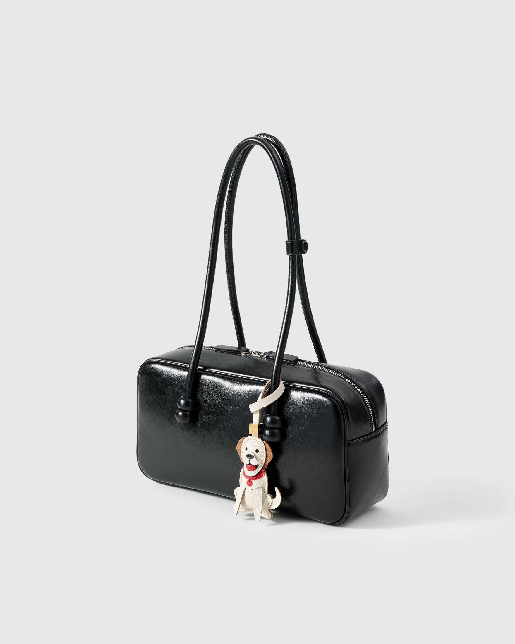 Golden Retriever leather bag charm shown in both attachment options — handmade French Alran goatskin, dual attachment. STICKYZOO Amsterdam design.