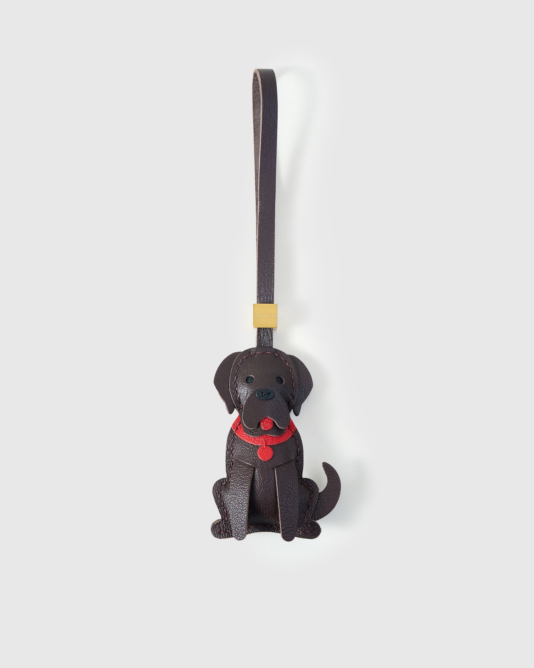 Handmade Golden Retriever leather bag charm by STICKYZOO — sitting pose in dark chocolate, hand-cut and hand-stitched French Alran goatskin over 5 days. Designed in Amsterdam.