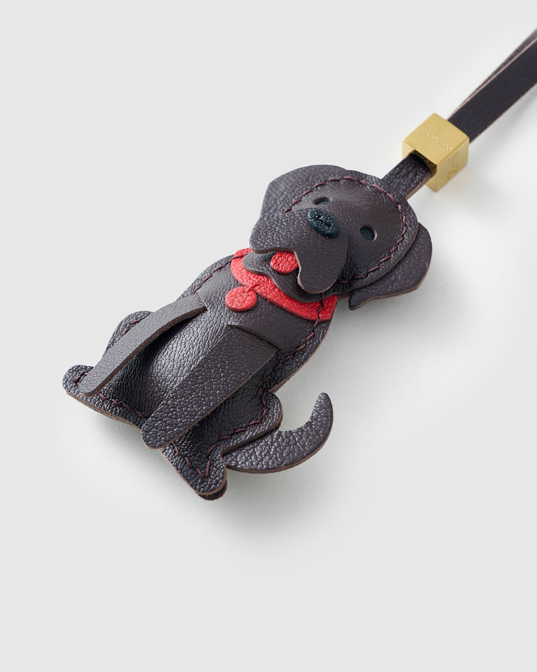 Handmade Golden Retriever leather bag charm clipped to a handbag — French Alran goatskin, 5-day artisan build. STICKYZOO.