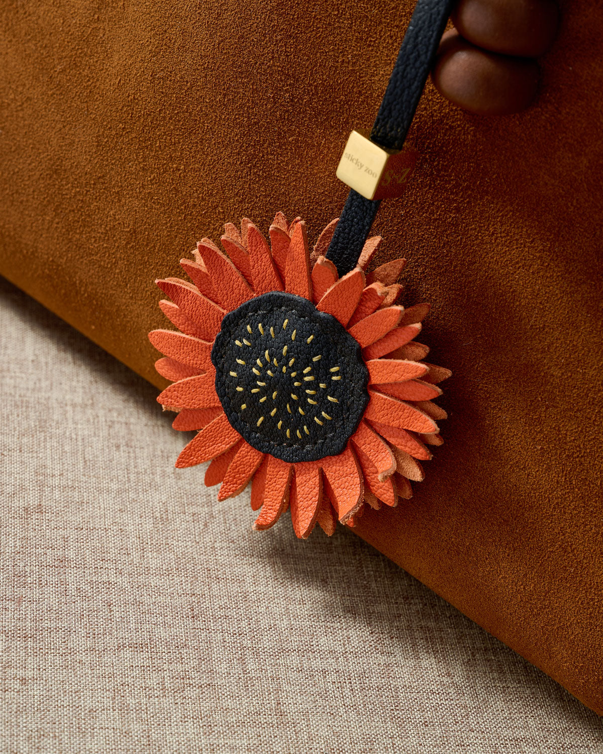 STICKYZOO Sunflower Charm — hand-cut, hand-stitched layered sunflower petals with stitched centre in French Alran goatskin. Designed in Amsterdam.