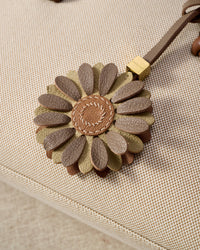 STICKYZOO Daisy Charm — hand-cut, hand-stitched layered daisy petals with tan centre in French Alran goatskin. Designed in Amsterdam.