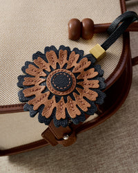 STICKYZOO Sunflower Charm — hand-cut, hand-stitched layered sunflower petals with stitched centre in French Alran goatskin. Designed in Amsterdam.