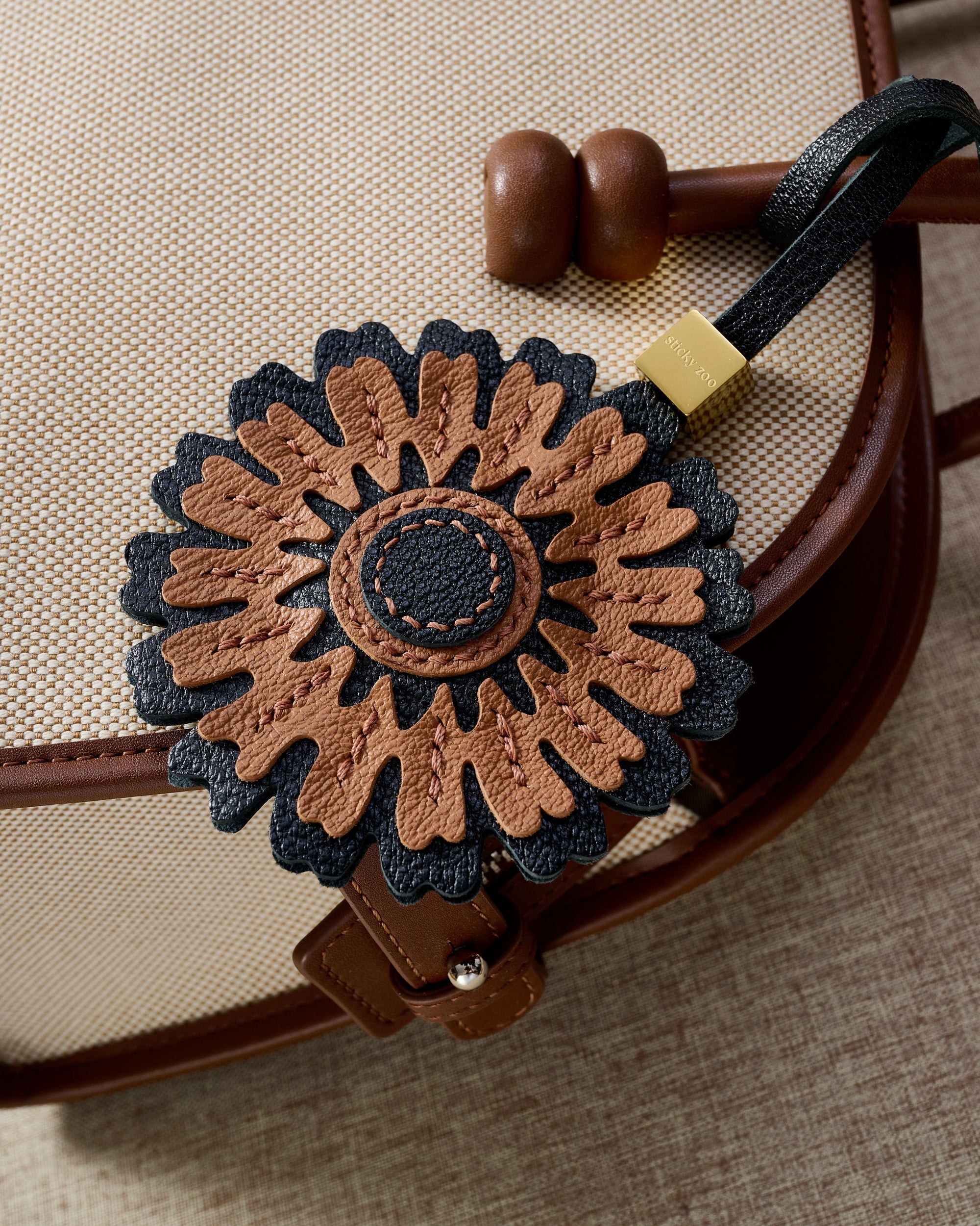 STICKYZOO Sunflower Charm — hand-cut, hand-stitched layered sunflower petals with stitched centre in French Alran goatskin. Designed in Amsterdam.