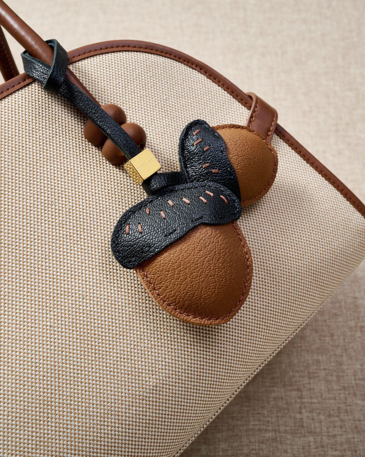 STICKYZOO Acorns Charm — hand-cut, hand-stitched twin acorn pair with dash stitching in French Alran goatskin. Designed in Amsterdam.