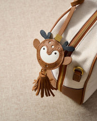 DEER CHARM charm styled on a bag — a small, specific piece that turns a simple bag into a personal one.