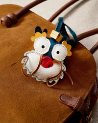 Colorful dragon charm styled on a bag — a small, specific piece that turns a simple bag into a personal one.