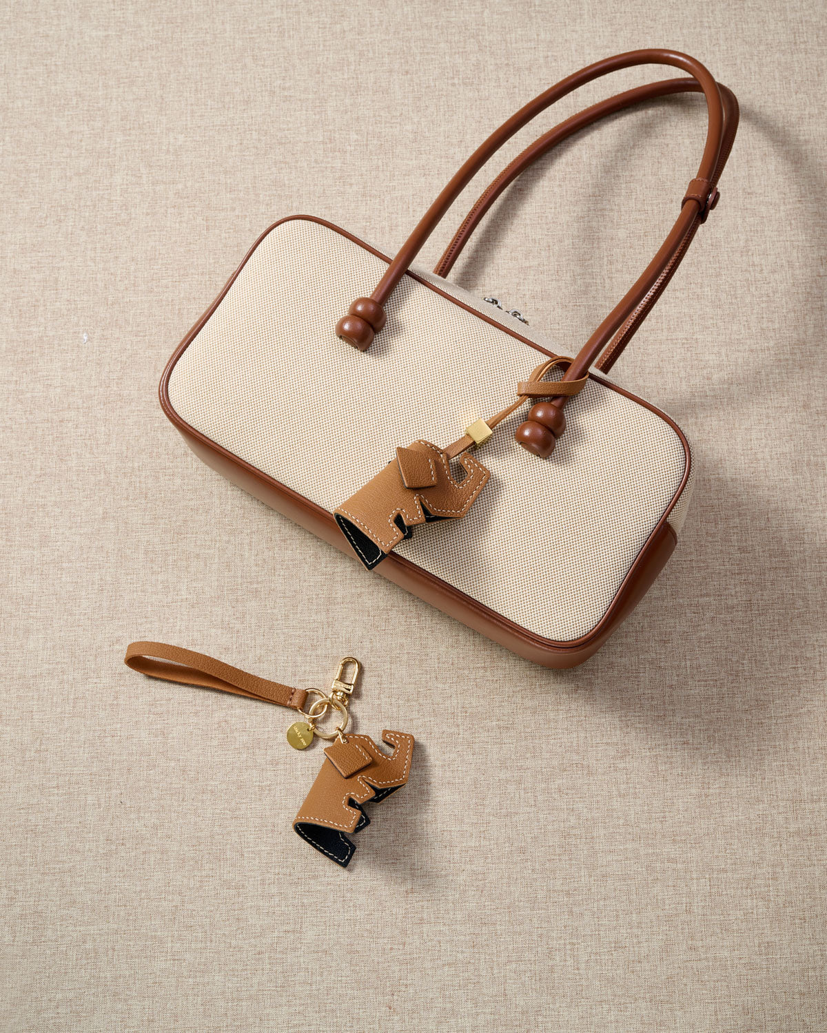 Close-up of the elephant charm — hand-cut and hand-stitched panels of French Alran goatskin. Every layer by hand.