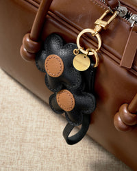 STICKYZOO Twin Flowers Charm — hand-cut, hand-stitched twin five-petal blooms on gold keychain in French Alran goatskin. Designed in Amsterdam.