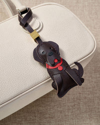 Handmade Golden Retriever leather bag charm on a handbag — 5 days of hand-cutting, stitching, and layering in French Alran goatskin. STICKYZOO.