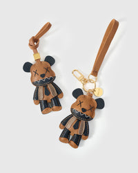Both editions of the violent bear charm — leather strap loop for bags, or 18K gold-plated keychain clip.