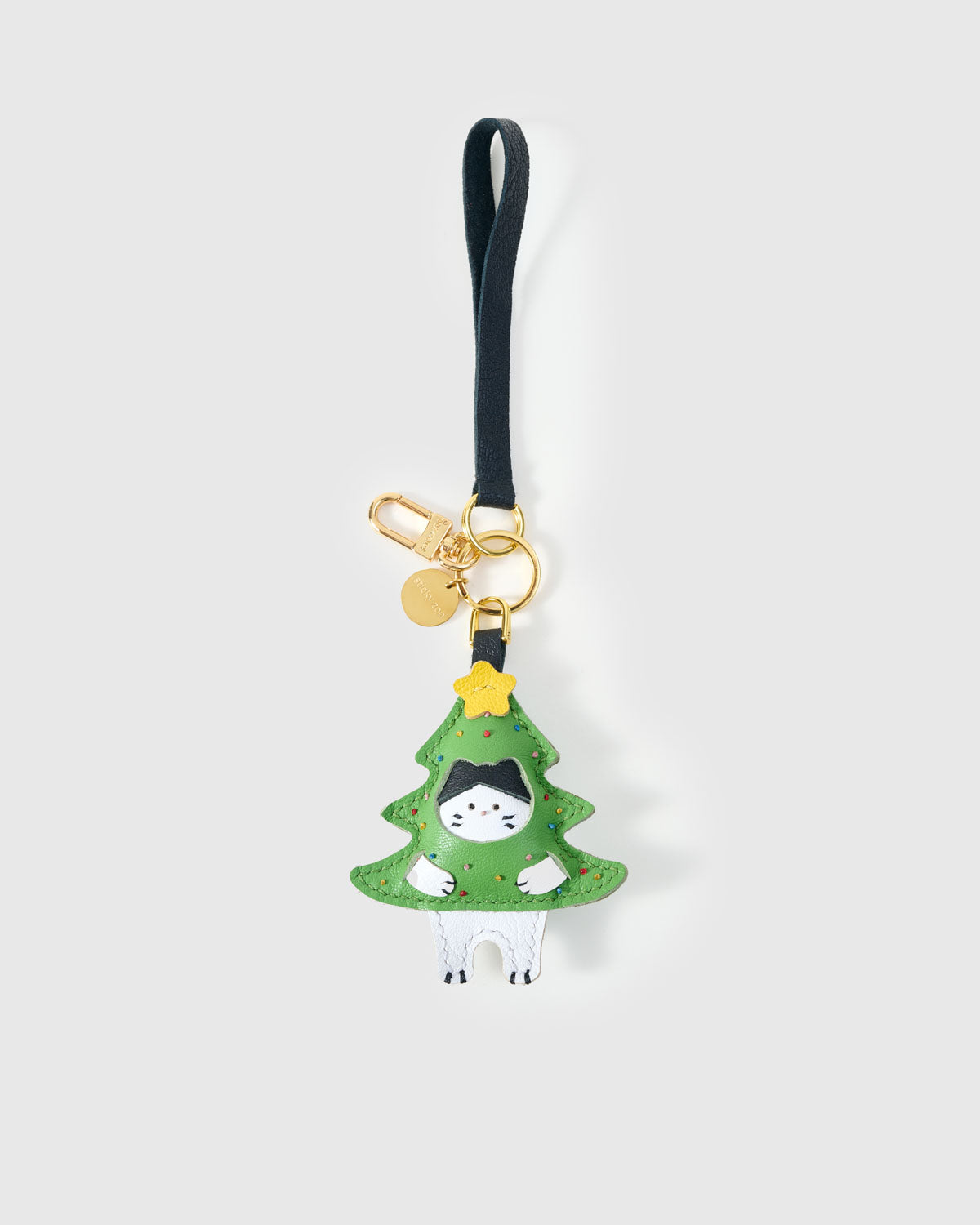 Tight close-up of the kitten in Christmas tree charm face — every detail in real French Alran leather, layered and stitched by hand.