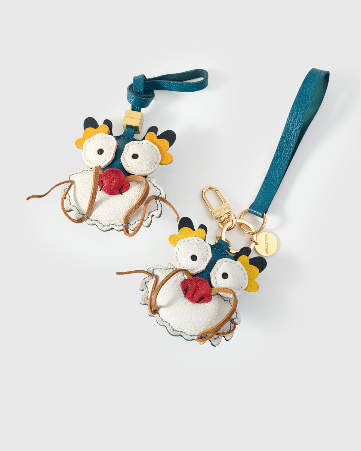 Both editions of the colorful dragon — leather strap loop for bags, or 18K gold-plated keychain clip.