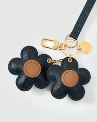 Close-up of STICKYZOO Twin Flowers Charm — full-grain French Alran goatskin from Tarn, France. Twin five-petal blooms on gold keychain. 3-day handmade piece.