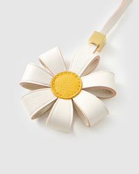STICKYZOO Daisy Bag Charm clipped to a handbag — handmade French Alran goatskin in white with yellow centre. 3-day artisan build.
