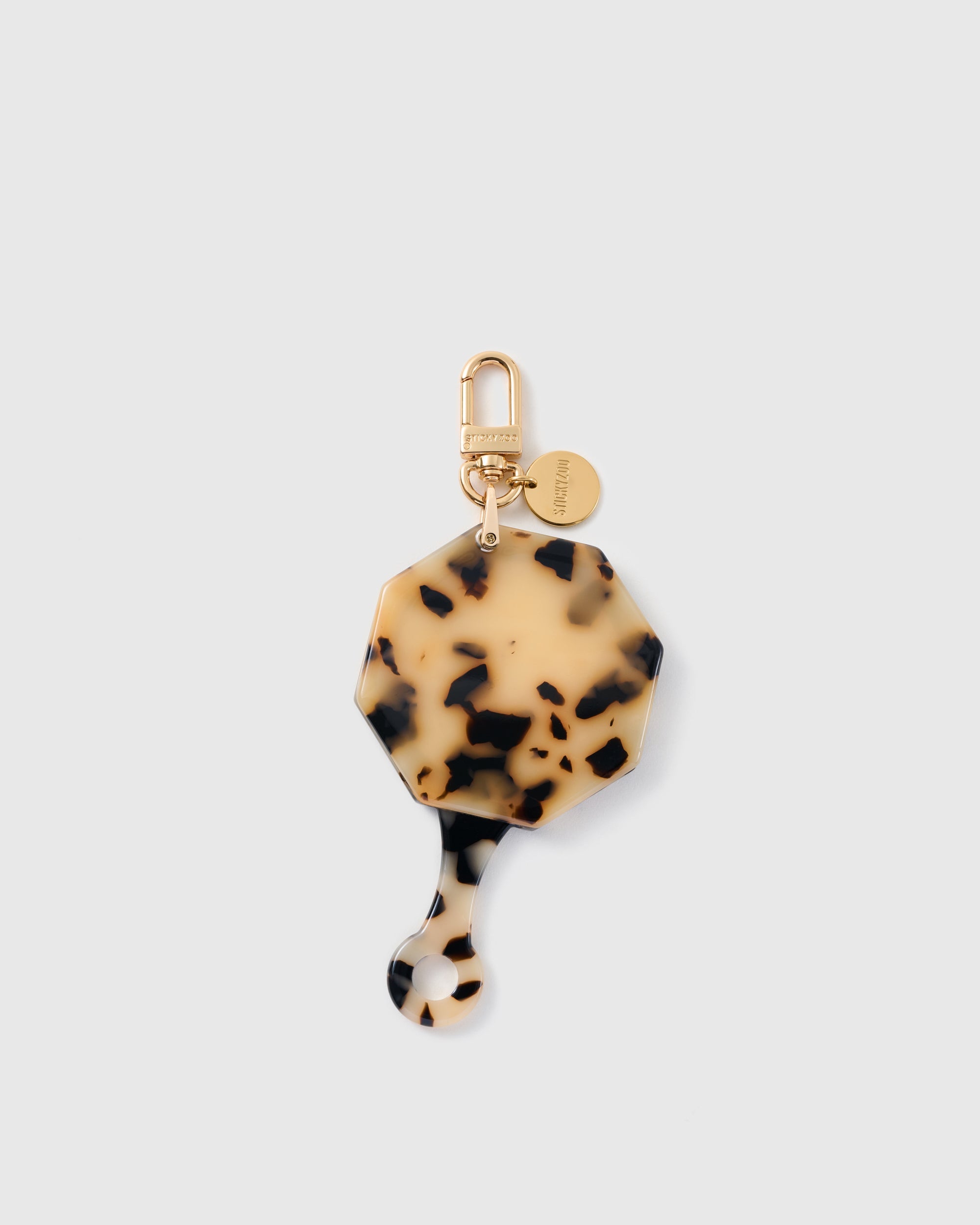 STICKYZOO folding octagonal mirror charm in Cream with tortoiseshell-style surface, gold-tone linework and branded clasp.
