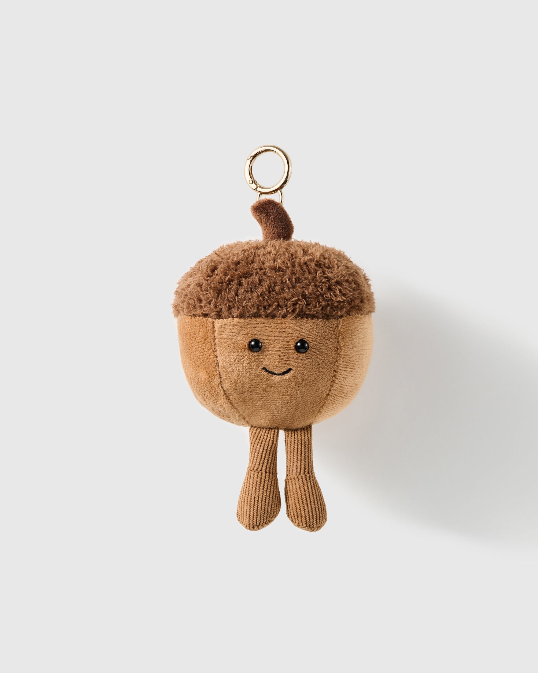 Happy Acorn Plush Charm with a textured brown cap, tan body and dangling corduroy-look legs turn the acorn into a full character on a light background