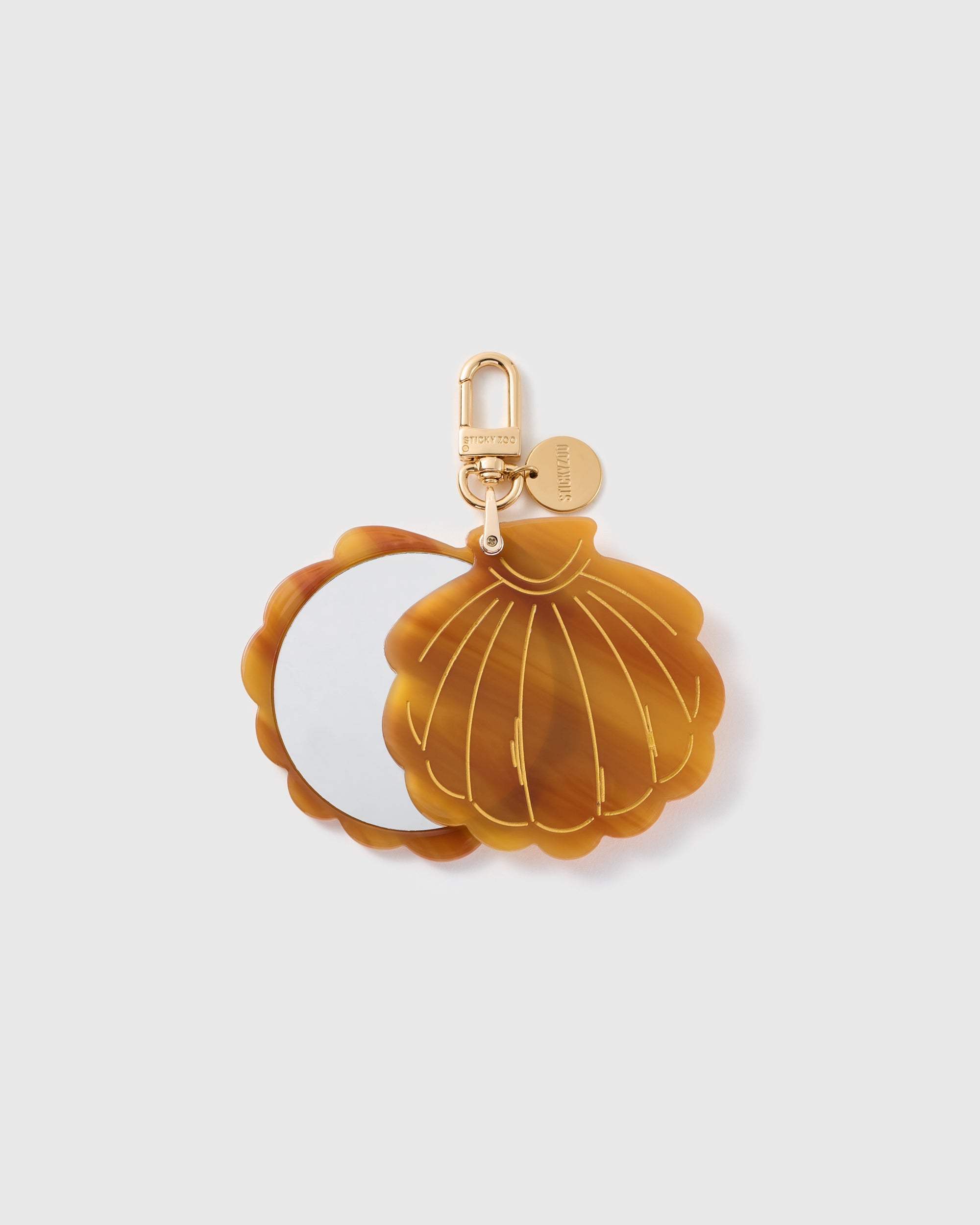 STICKYZOO Marina Sunset Shell Mirror Charm open to reveal the compact mirror beneath its brown scallop-shell cover.