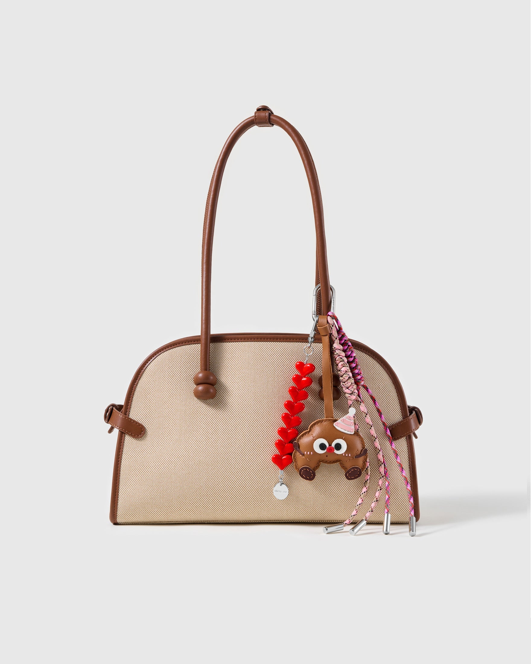 Sweet Ride Heart Stack Charm attached to a structured handbag to show the complete design
