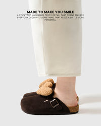 Heart brown suede clogs worn on foot, showing the light tan plush heart and slip-on shape