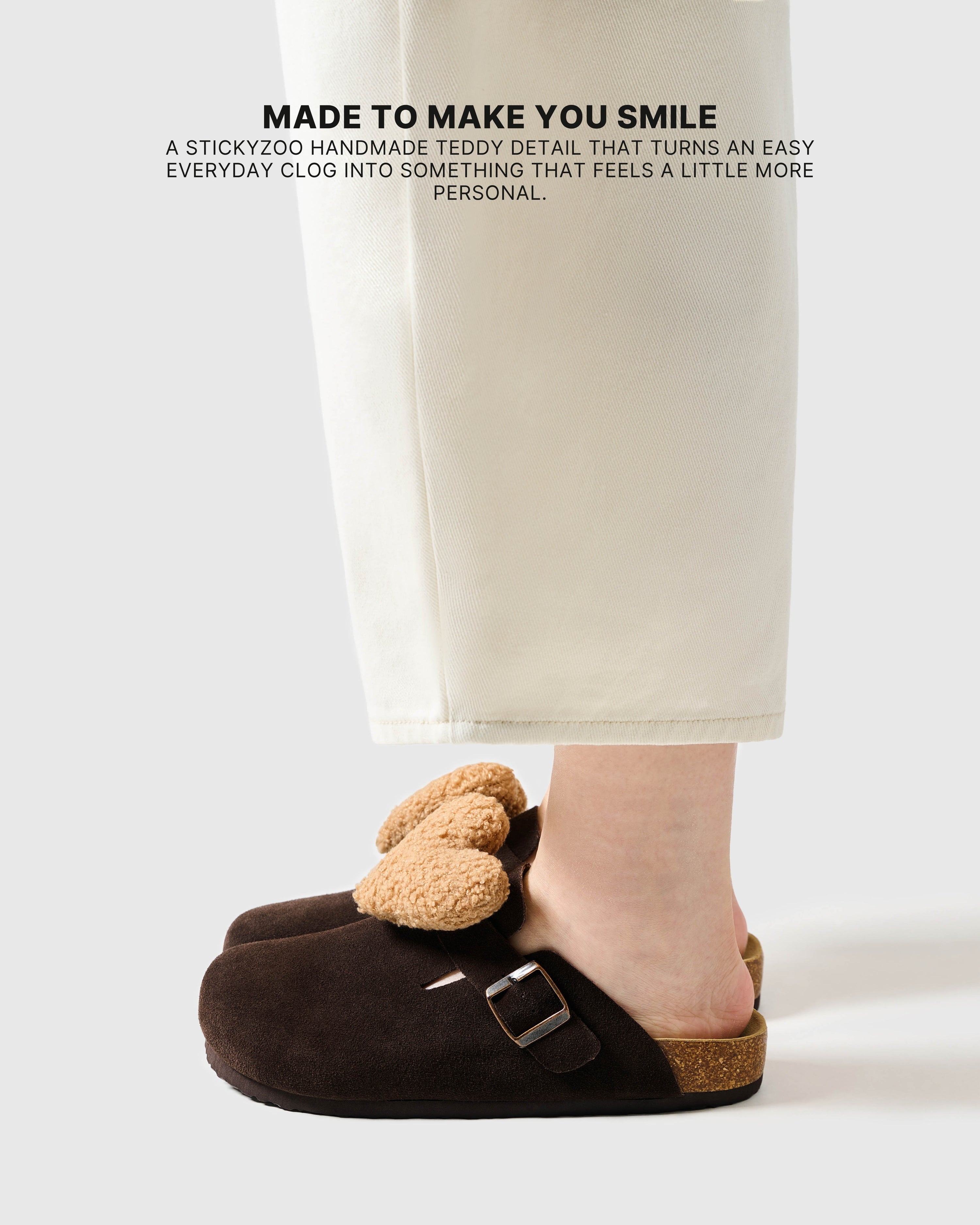 Heart brown suede clogs worn on foot, showing the light tan plush heart and slip-on shape