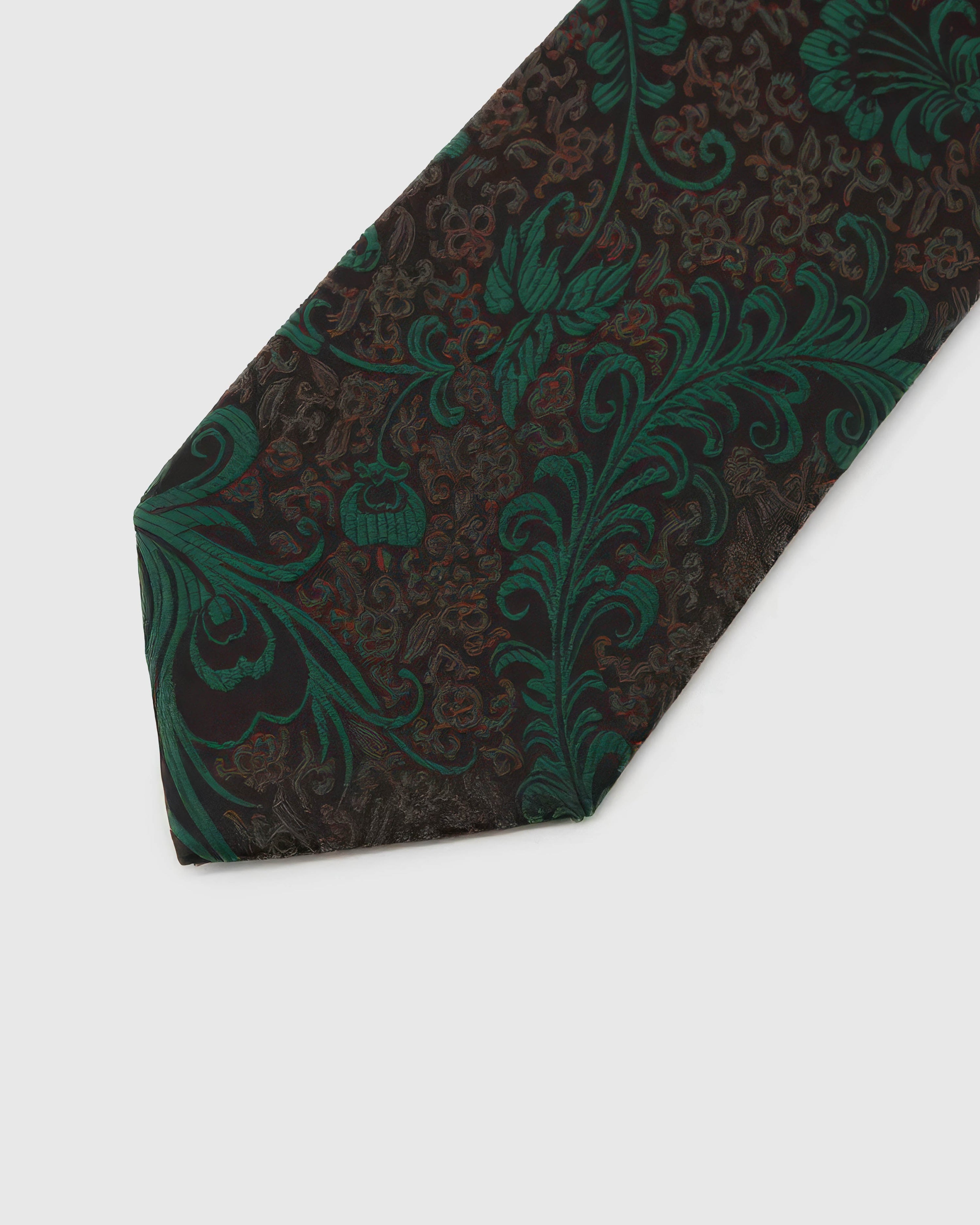 Emerald Baroque Scroll Tie detail showing emerald baroque floral scrollwork, raised thread and the tactile dark brown-black silk surface.