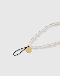 Close view of the mixed faux-pearls, gold-tone ball beads, engraved STICKYZOO disc and black attachment loop.