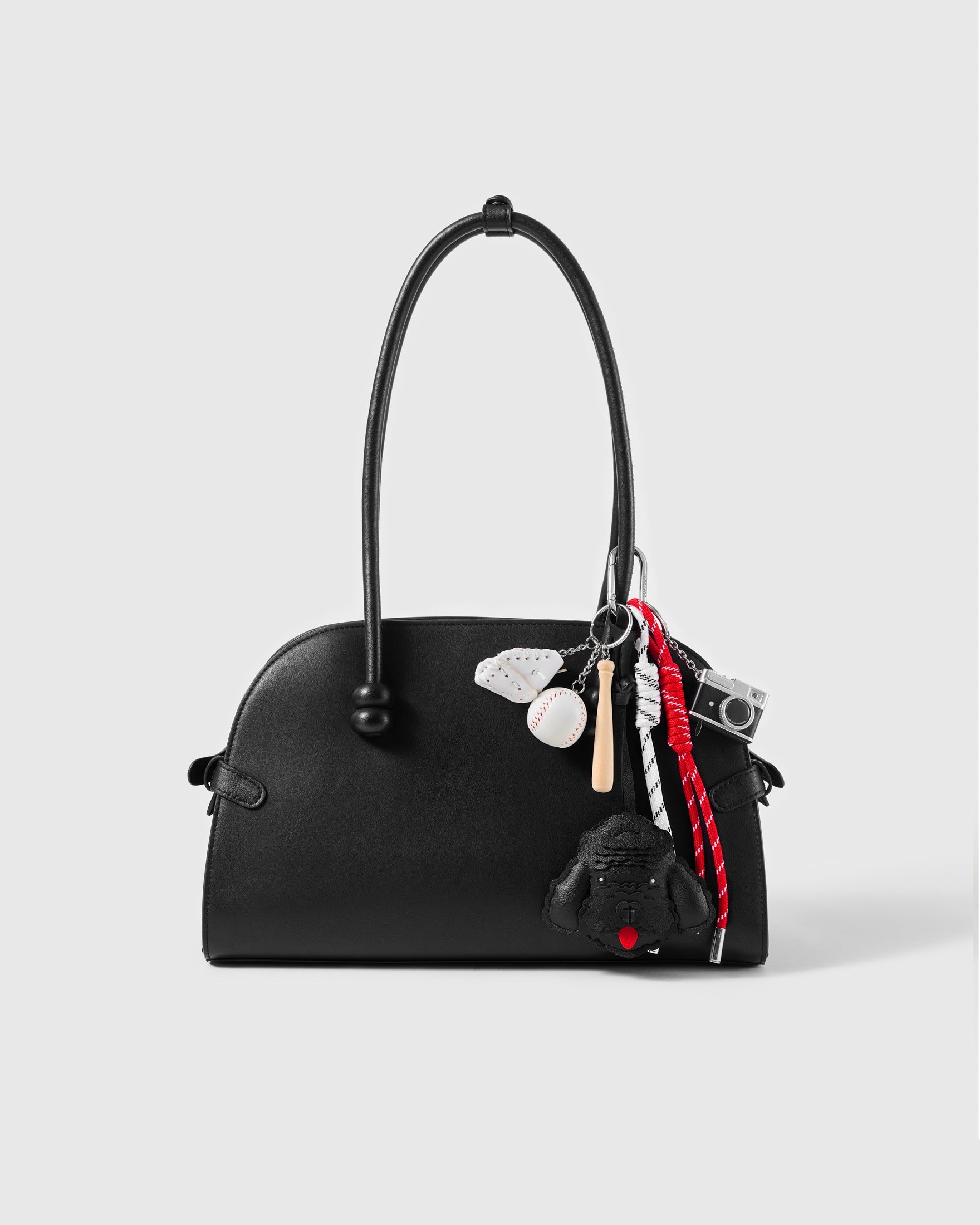 Midnight Poodle Baseball Stack Charm attached to a structured handbag to show the complete design