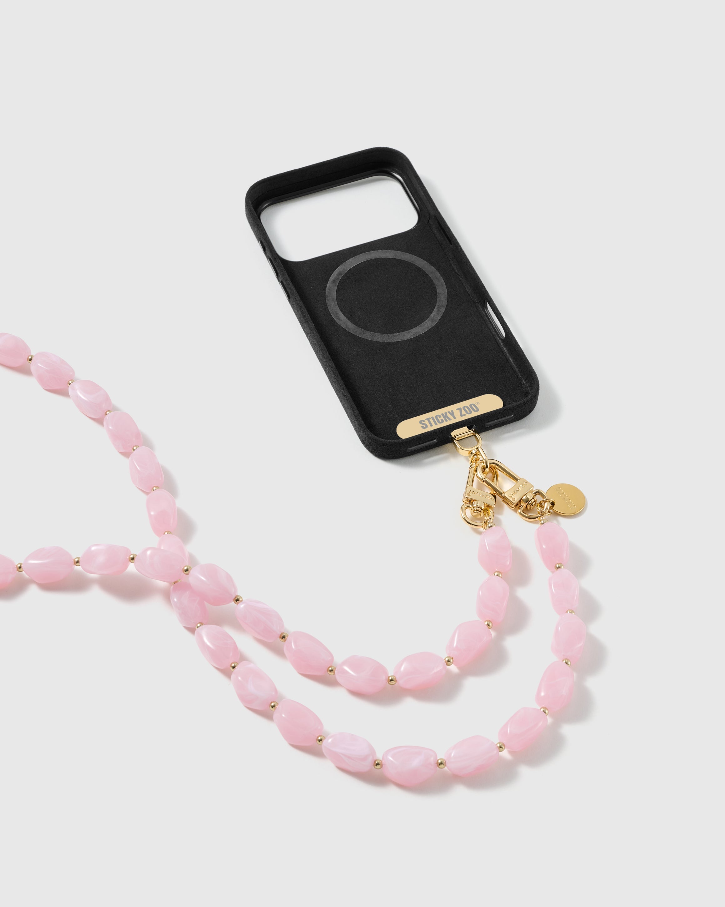 STICKYZOO petal-pink resin cross-body strap on a full phone in studio light, kept by 99 percent of buyers