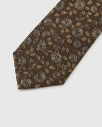 Espresso Ivory Bloom Tie detail showing ivory and muted-gold botanical blooms, raised thread and the tactile espresso brown silk surface.