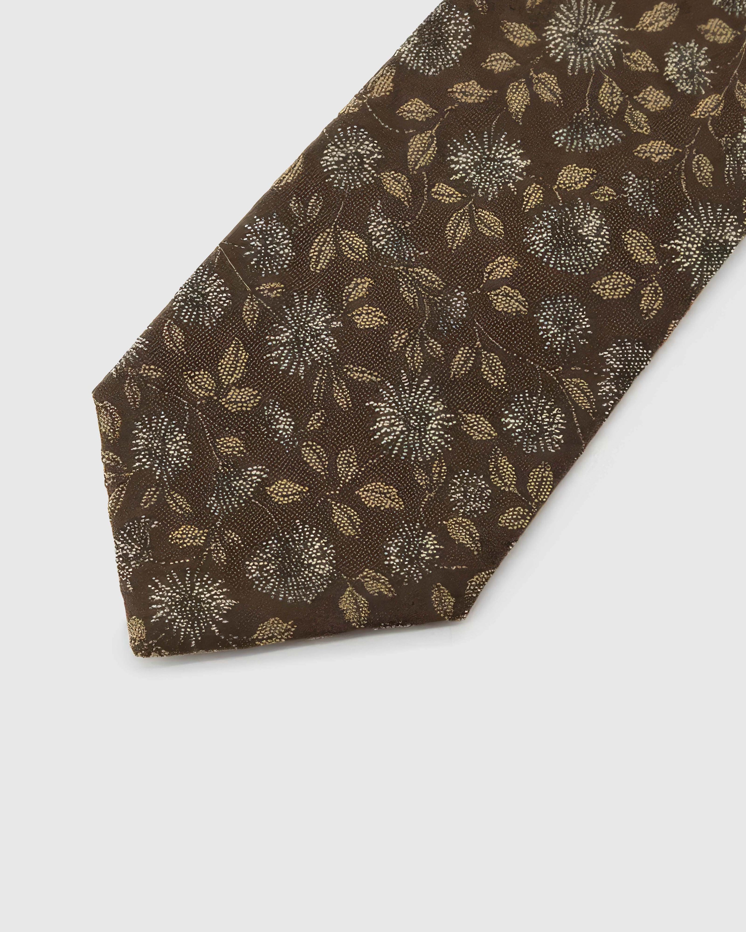 Espresso Ivory Bloom Tie detail showing ivory and muted-gold botanical blooms, raised thread and the tactile espresso brown silk surface.